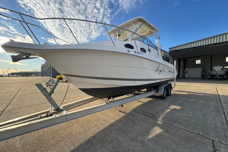  Yacht Photos Pics 2009 Wellcraft 270 Coastal O/B boat on trailer under clear blue sky.