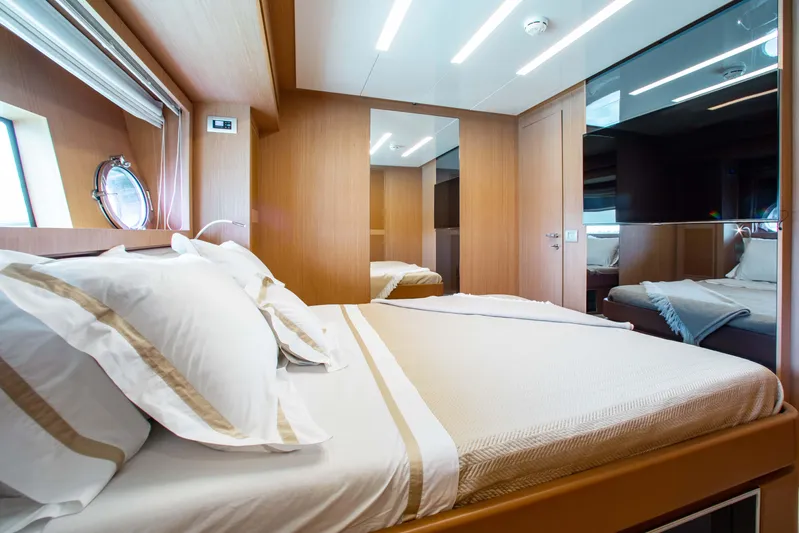 Lady Elkie Yacht Photos Pics Luxurious bedroom interior on a 2016 Riva 88' Florida yacht, featuring elegant wood finishes.