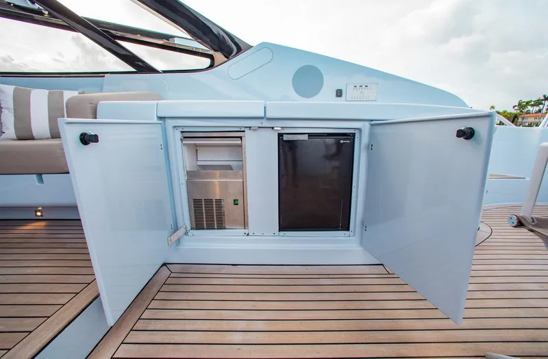 Lady Elkie Yacht Photos Pics Riva 88' Florida 2016 yacht interior with open cabinet revealing mini fridge and ice maker.