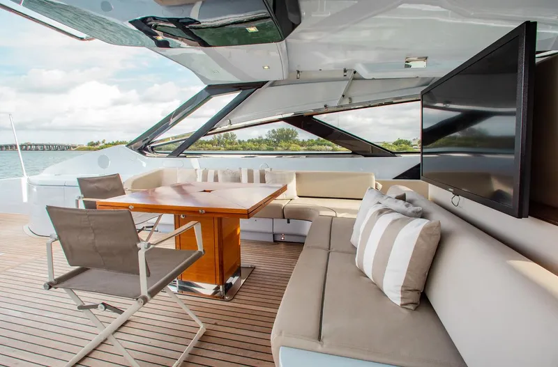 Lady Elkie Yacht Photos Pics Luxurious 2016 Riva 88' Florida yacht deck with seating, table, and TV.
