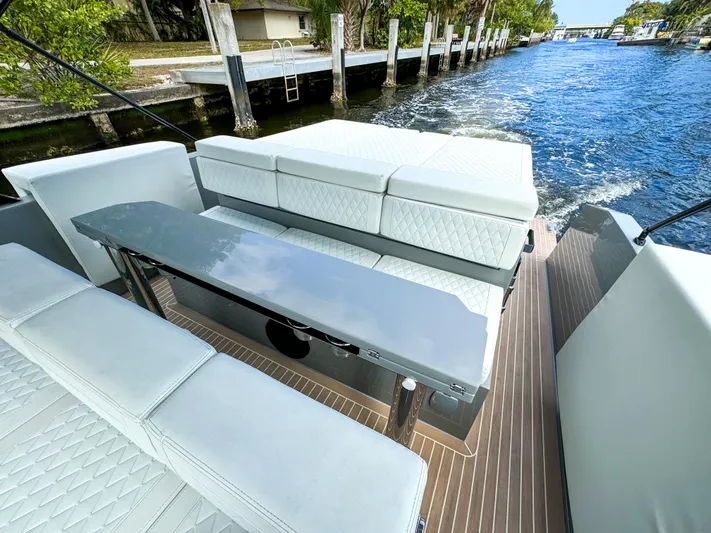  Yacht Photos Pics 2024 De Antonio Yachts D28 Cruiser, elegant seating area on deck, cruising along a scenic waterway.