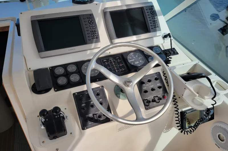 Reely Blessed Yacht Photos Pics Control panel of a 1998 Cabo 31 Express with Tower, featuring Garmin displays and steering wheel.