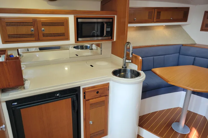 Reely Blessed Yacht Photos Pics 1998 Cabo 31 Express interior with kitchenette, microwave, sink, and cozy seating area.