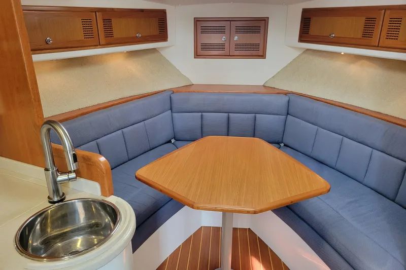 Reely Blessed Yacht Photos Pics Interior of 1998 Cabo 31 Express with Tower, featuring cozy seating and wooden table.