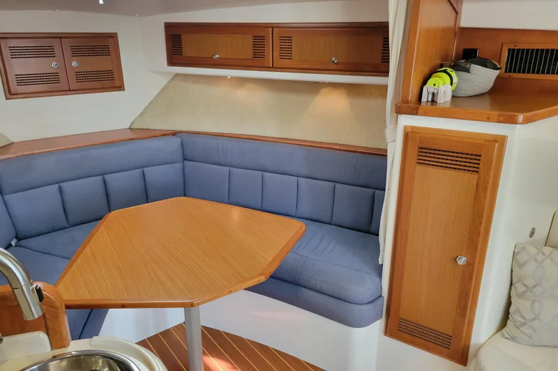 Reely Blessed Yacht Photos Pics 1998 Cabo 31 Express interior with blue seating and wooden table.