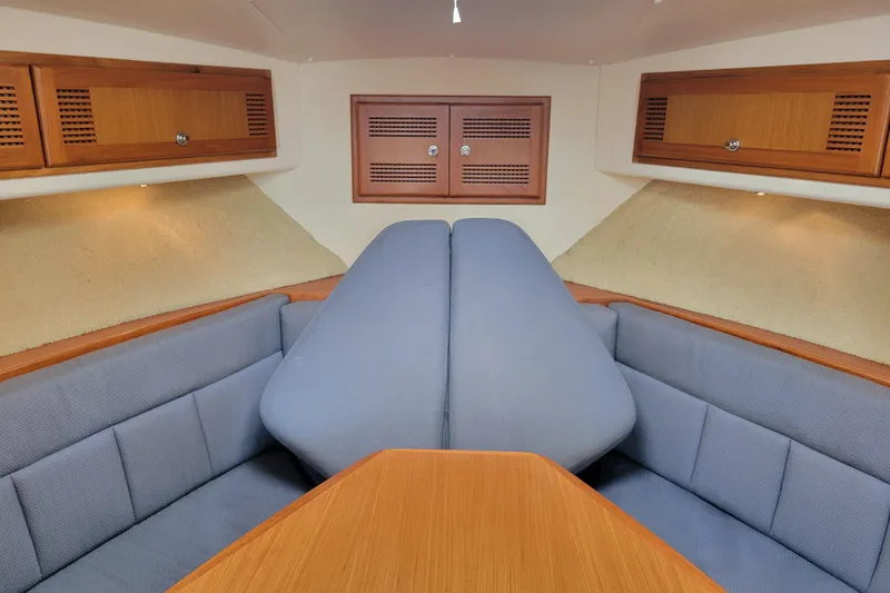 Reely Blessed Yacht Photos Pics 1998 Cabo 31 Express cabin interior with blue seating and wooden cabinetry.