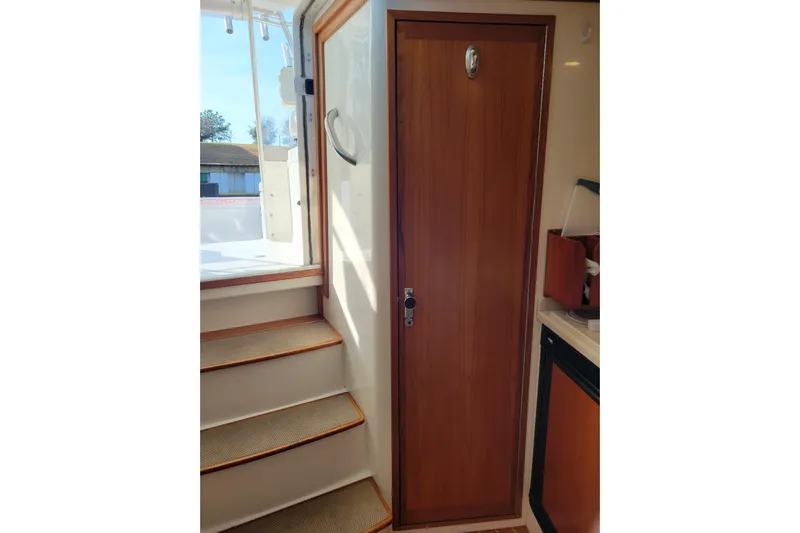 Reely Blessed Yacht Photos Pics Interior view of 1998 Cabo 31 Express with Tower, featuring wooden door and stairs.