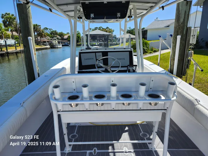  Yacht Photos Pics 2001 Jupiter 31 Open Center Console boat docked by a canal, featuring rod holders and steering console.