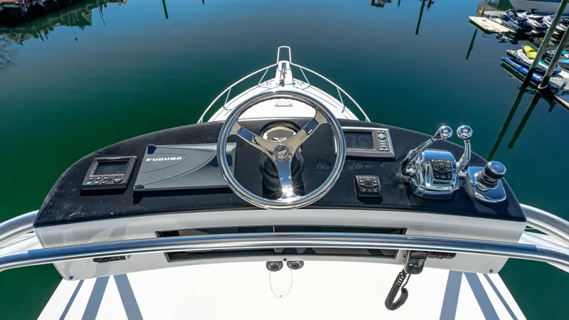  Yacht Photos Pics 2014 Viking 42 Open helm with steering wheel and controls, docked on calm water.