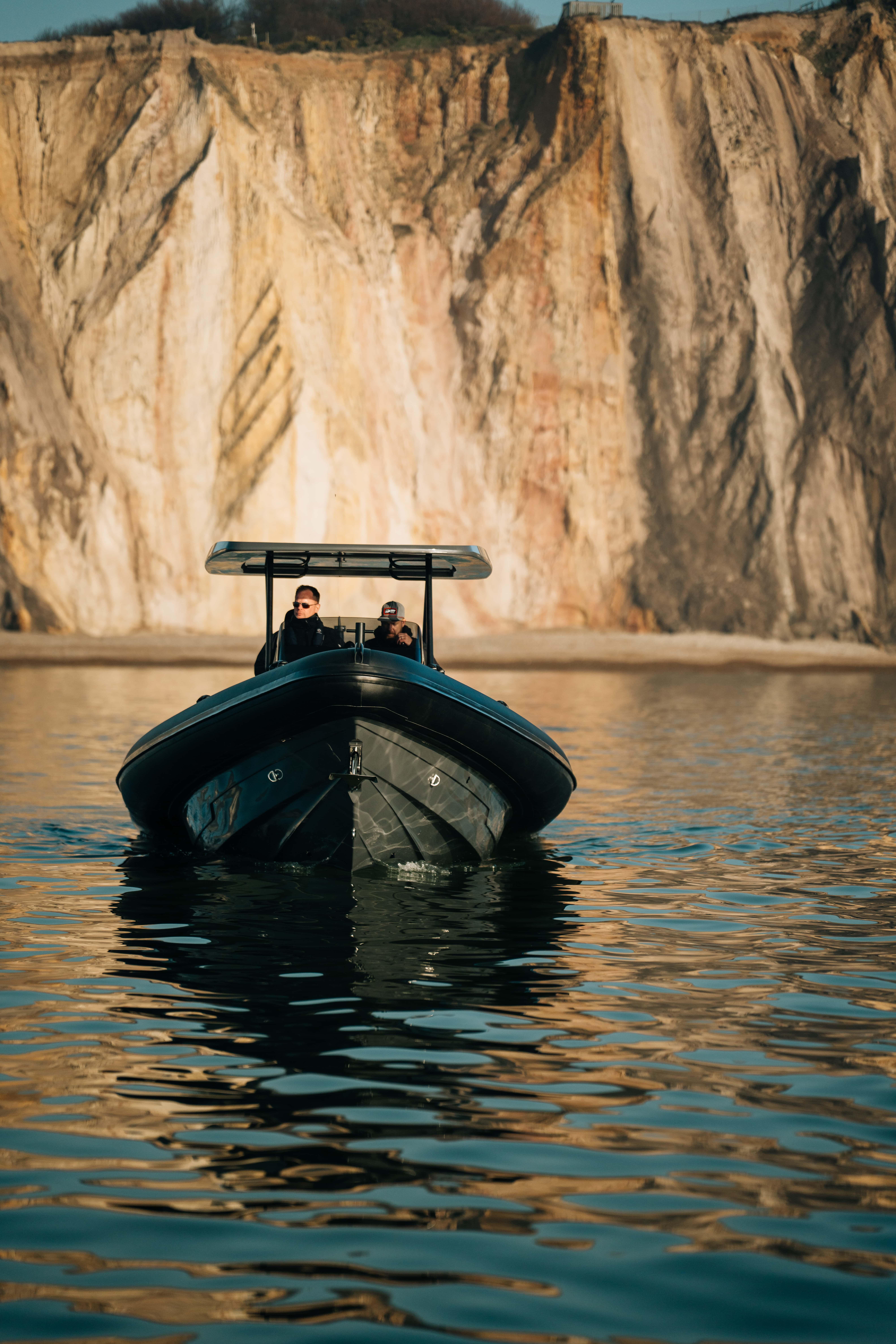 2025 Scorpion Grand Tourer 36 boat on calm water with cliffs in the background.