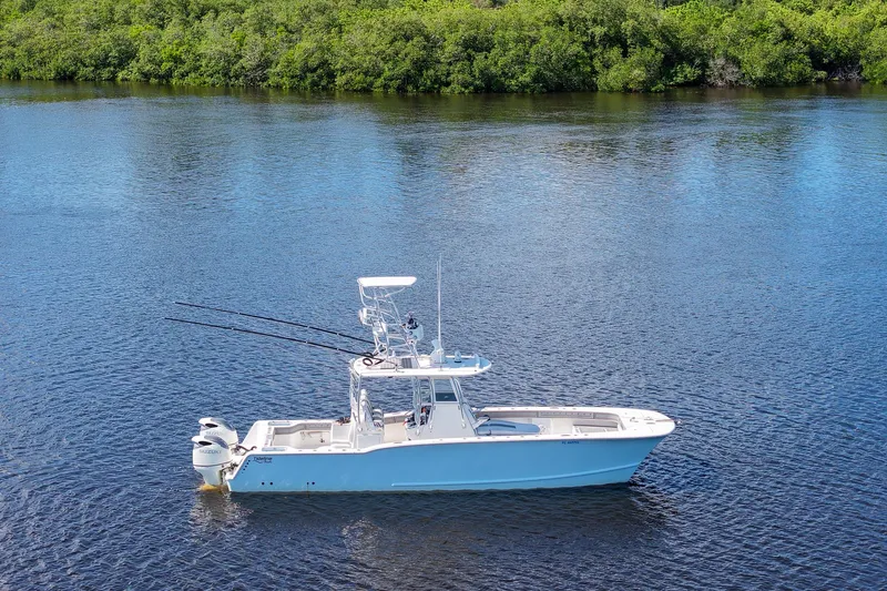  Yacht Photos Pics 2020 Tideline 365 Offshore boat on calm water with lush green shoreline.