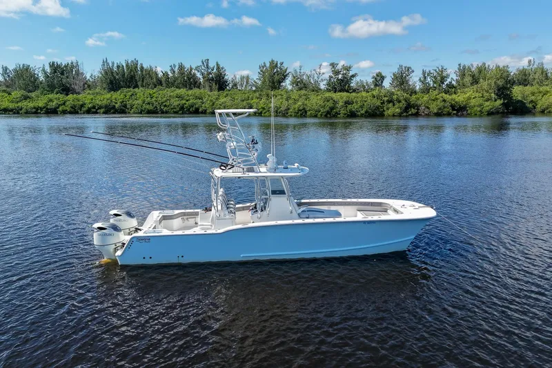  Yacht Photos Pics 2020 Tideline 365 Offshore boat on calm water, surrounded by lush greenery.