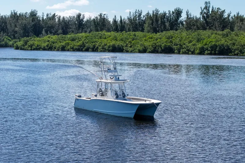 Yacht Photos Pics 2020 Tideline 365 Offshore boat on calm water with lush green shoreline.