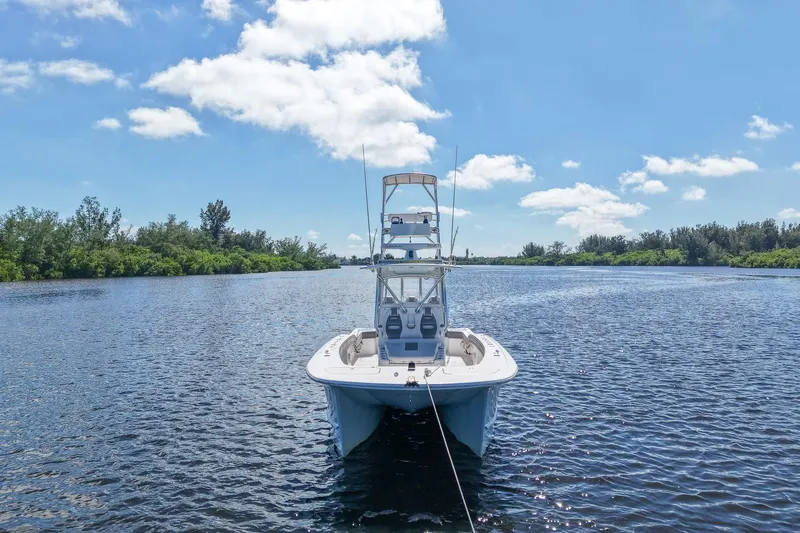  Yacht Photos Pics 2020 Tideline 365 Offshore boat on a serene river under a clear blue sky.