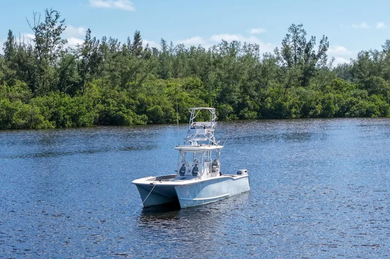  Yacht Photos Pics 2020 Tideline 365 Offshore boat on a serene lake with lush green trees.
