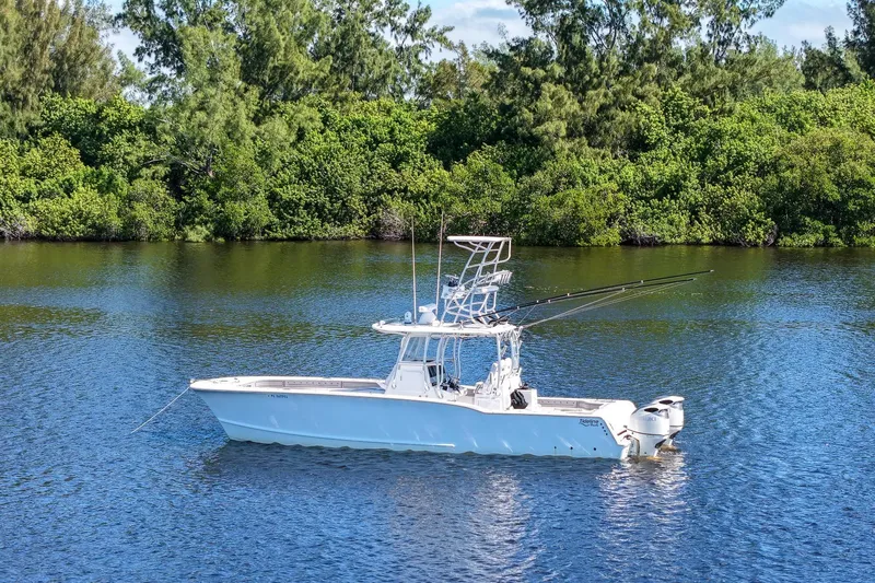  Yacht Photos Pics 2020 Tideline 365 Offshore boat on calm water, surrounded by lush greenery.