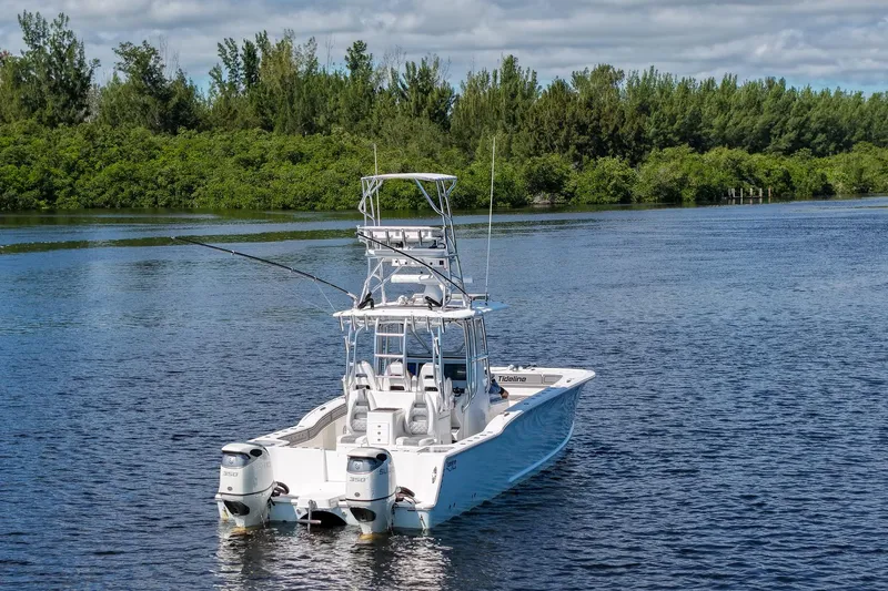  Yacht Photos Pics 2020 Tideline 365 Offshore boat on a serene lake with lush greenery.