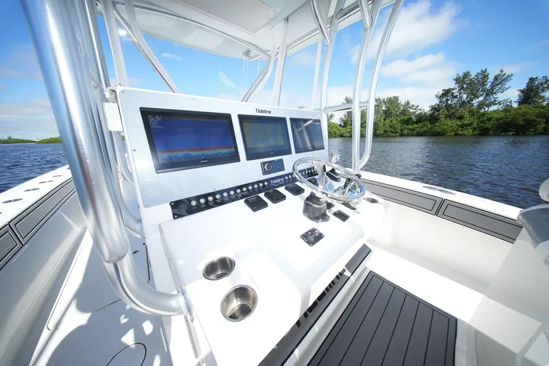  Yacht Photos Pics 2020 Tideline 365 Offshore boat dashboard with dual screens and steering wheel on a sunny day.