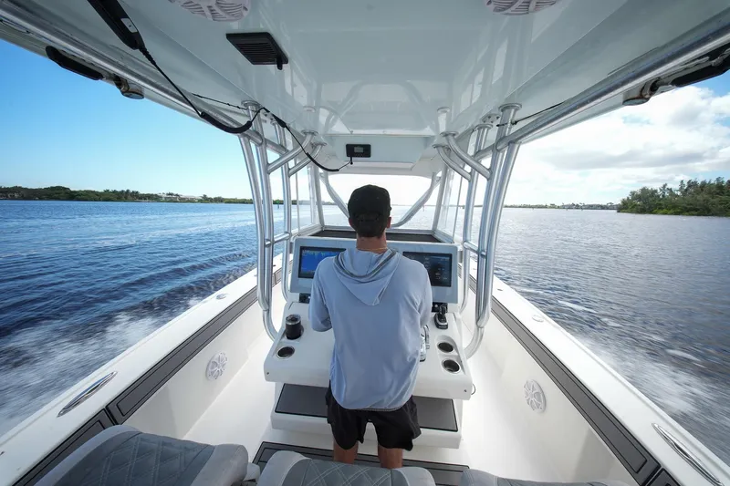  Yacht Photos Pics Person steering 2020 Tideline 365 Offshore boat on open water.