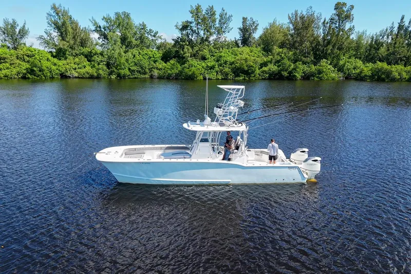  Yacht Photos Pics 2020 Tideline 365 Offshore boat on calm water, surrounded by lush greenery.