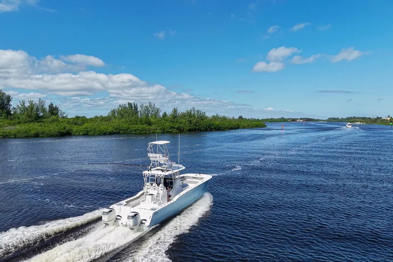  Yacht Photos Pics 2020 Tideline 365 Offshore boat cruising on a scenic river under a clear blue sky.