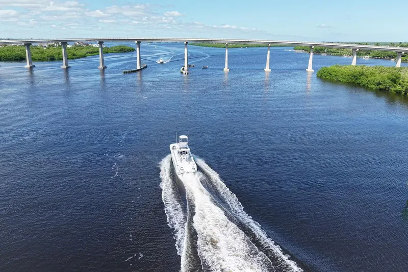  Yacht Photos Pics Aerial view of 2020 Tideline 365 Offshore boat cruising under a bridge on a sunny day.