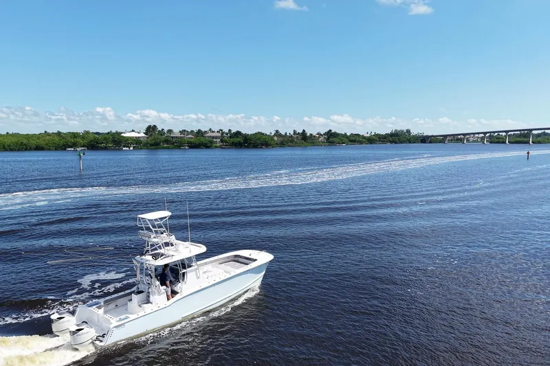  Yacht Photos Pics 2020 Tideline 365 Offshore boat cruising on a sunny day near a bridge.