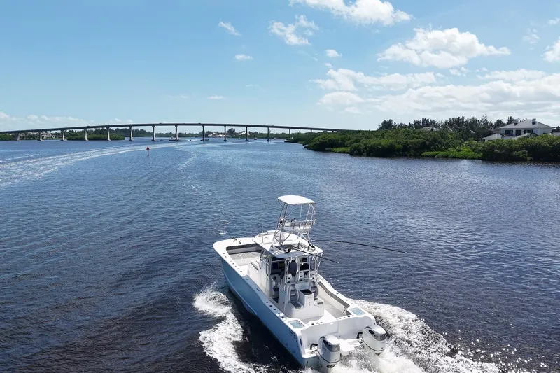  Yacht Photos Pics 2020 Tideline 365 Offshore boat cruising on a scenic river under a clear blue sky.