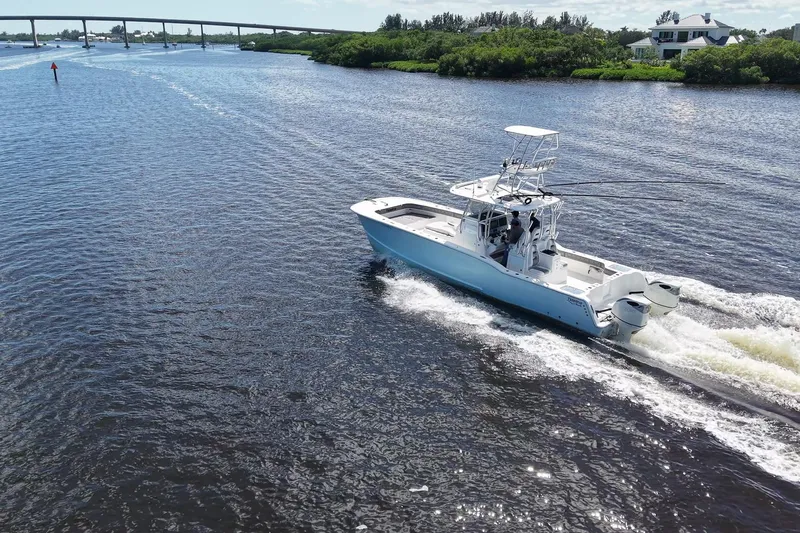  Yacht Photos Pics 2020 Tideline 365 Offshore boat cruising on a scenic waterway with lush greenery.