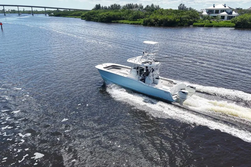  Yacht Photos Pics 2020 Tideline 365 Offshore boat cruising on a scenic river with lush greenery.