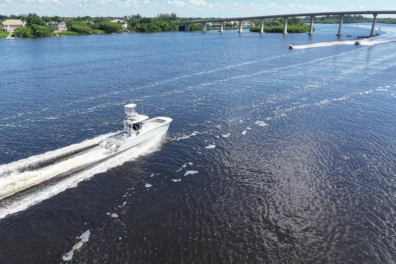  Yacht Photos Pics 2020 Tideline 365 Offshore boat cruising on a scenic river near a bridge.