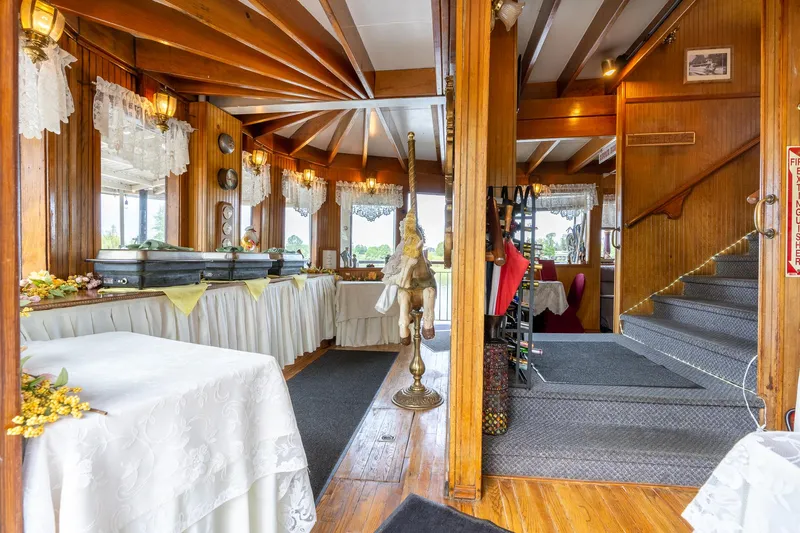 Willamette Queen Yacht Photos Pics Elegant interior of 1990 Custom Howdy Eidelman Sternwheeler, featuring wood paneling and dining setup.