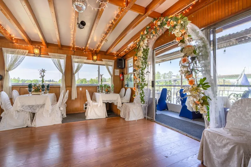 Willamette Queen Yacht Photos Pics Luxurious 1990 Custom Howdy Eidelman Sternwheeler interior with elegant floral arch and decorated tables.