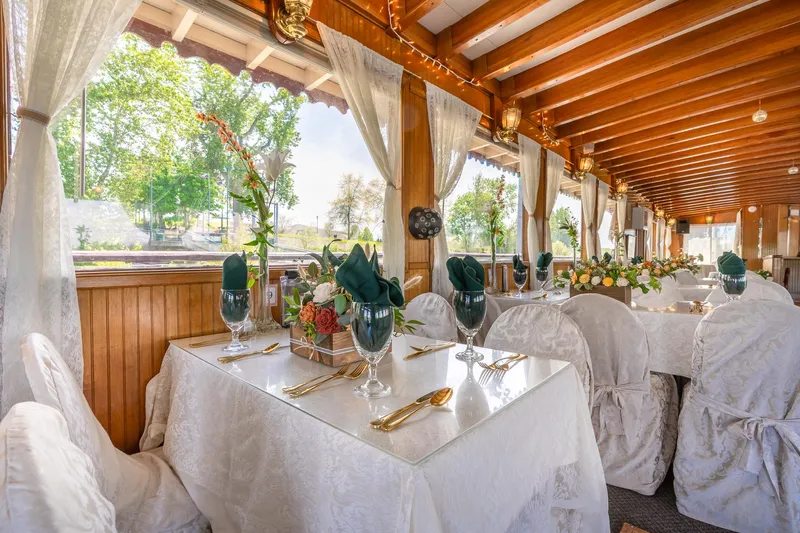Willamette Queen Yacht Photos Pics Elegant dining setup on 1990 Howdy Eidelman Sternwheeler, featuring white linens and floral arrangements.