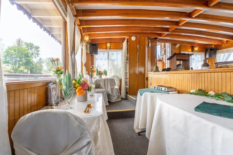Willamette Queen Yacht Photos Pics Elegant interior of 1990 Custom Howdy Eidelman Sternwheeler, featuring wooden beams and decorated tables.