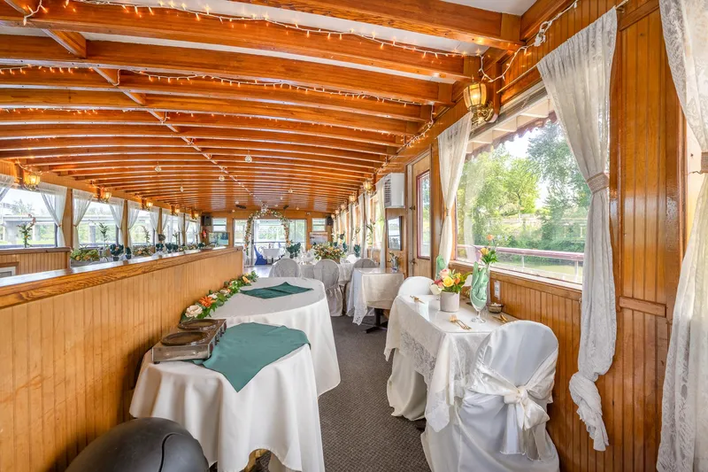 Willamette Queen Yacht Photos Pics Elegant interior of 1990 Custom Howdy Eidelman Sternwheeler, featuring wooden decor and draped tables.