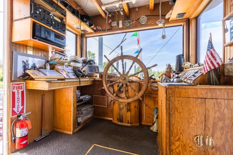 Willamette Queen Yacht Photos Pics Pilot house of 1990 Howdy Eidelman Sternwheeler, featuring wooden helm and nautical decor.