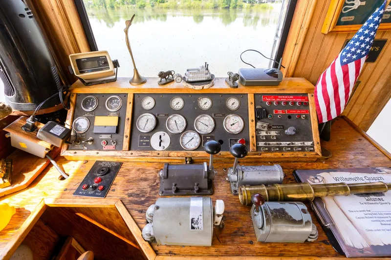 Willamette Queen Yacht Photos Pics Control panel of 1990 Custom Howdy Eidelman Sternwheeler, featuring gauges and American flag.