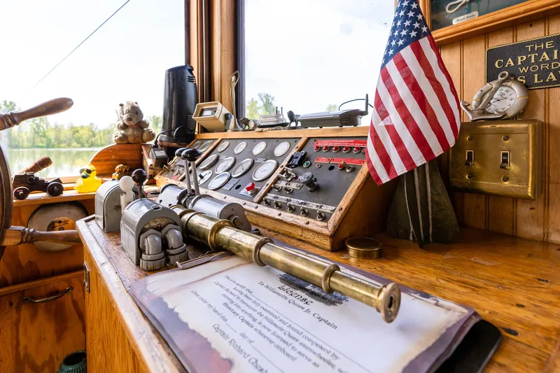 Willamette Queen Yacht Photos Pics Captain's cabin of 1990 Custom Howdy Eidelman Sternwheeler, featuring vintage controls and American flag.