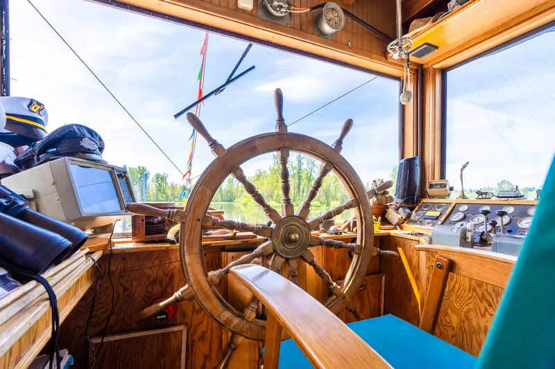 Willamette Queen Yacht Photos Pics Pilot house of 1990 Custom Howdy Eidelman Sternwheeler, featuring wooden steering wheel and navigation equipment.