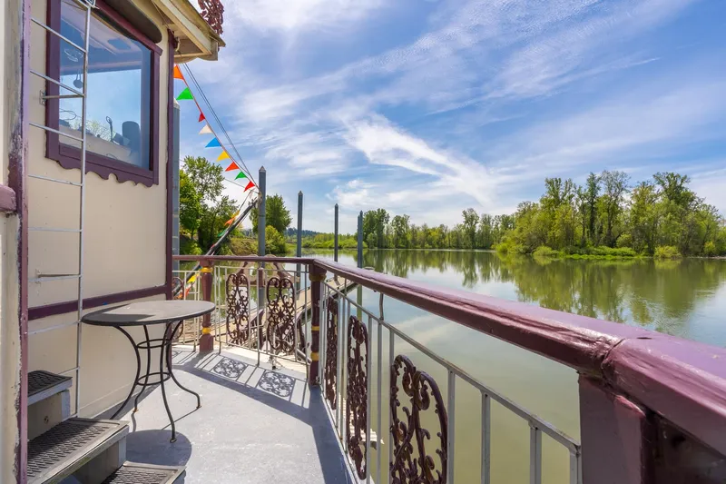 Willamette Queen Yacht Photos Pics Balcony view from 1990 Custom Howdy Eidelman Sternwheeler, overlooking serene river and lush greenery.