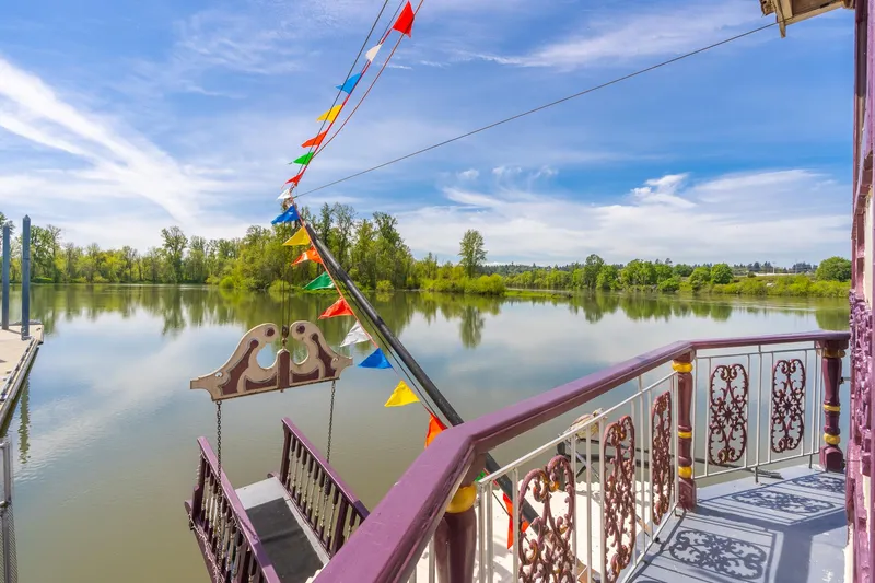 Willamette Queen Yacht Photos Pics Colorful flags adorn a 1990 Custom Howdy Eidelman Sternwheeler on a serene river.