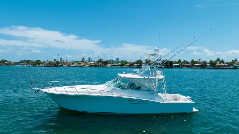 Fancy Yacht Photos Pics 2000 Cabo 45 Express yacht on calm blue water under clear sky.
