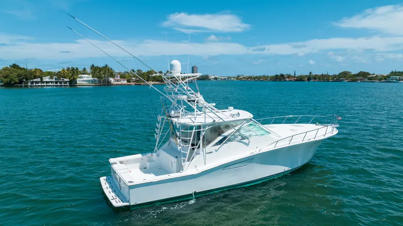 Fancy Yacht Photos Pics 2000 Cabo 45 Express yacht on clear blue water under a sunny sky.