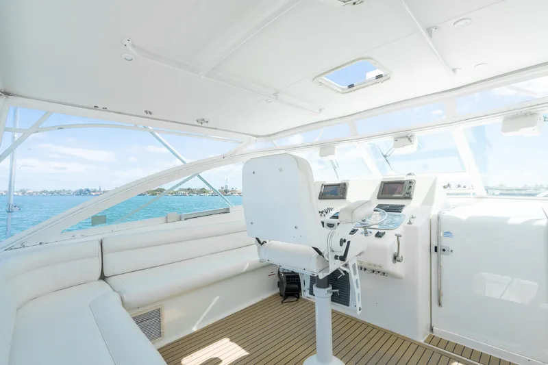 Fancy Yacht Photos Pics Interior of 2000 Cabo 45 Express yacht with helm and seating, overlooking ocean.