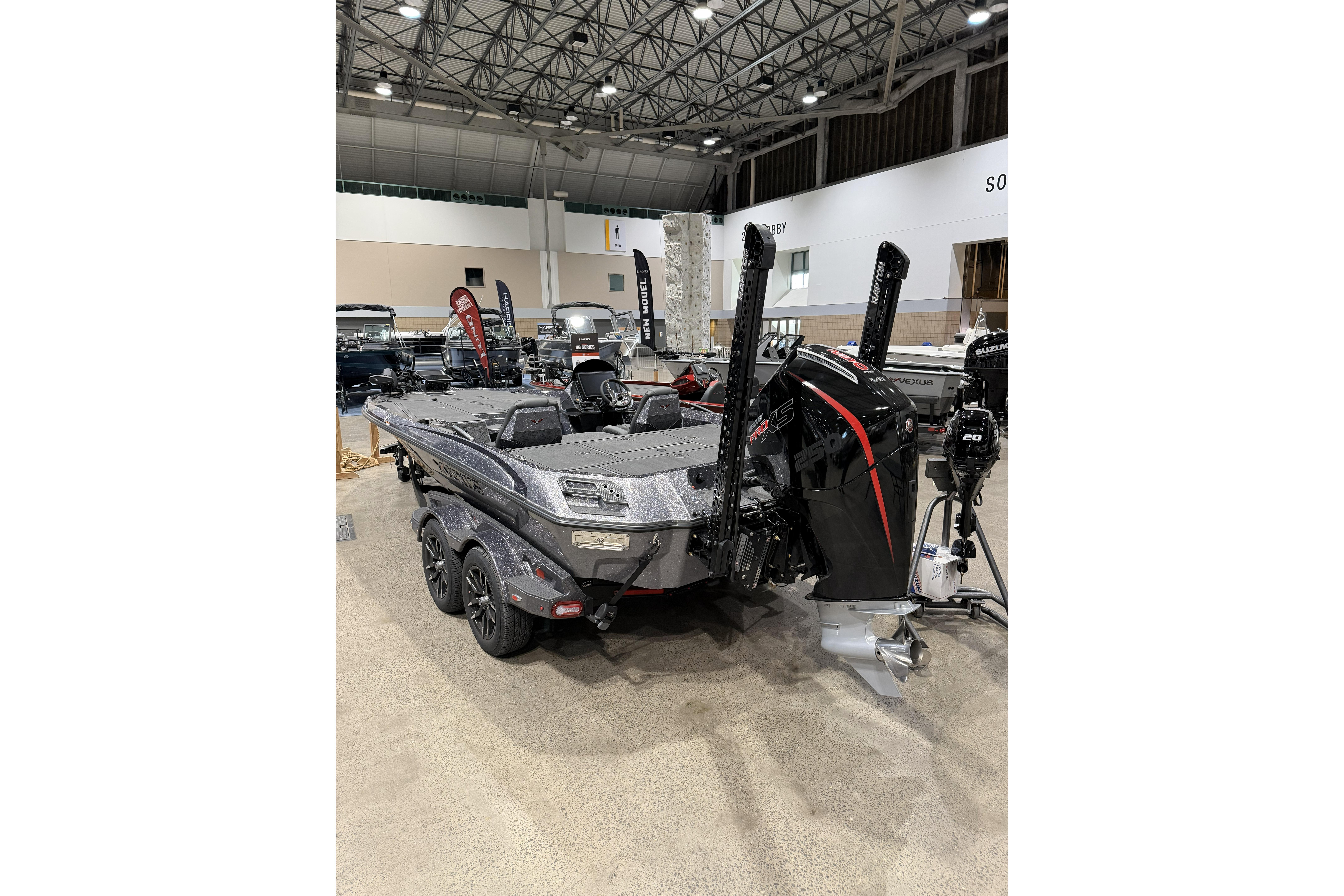 2026 Vexus boat displayed indoors, featuring a powerful outboard motor and sleek design.