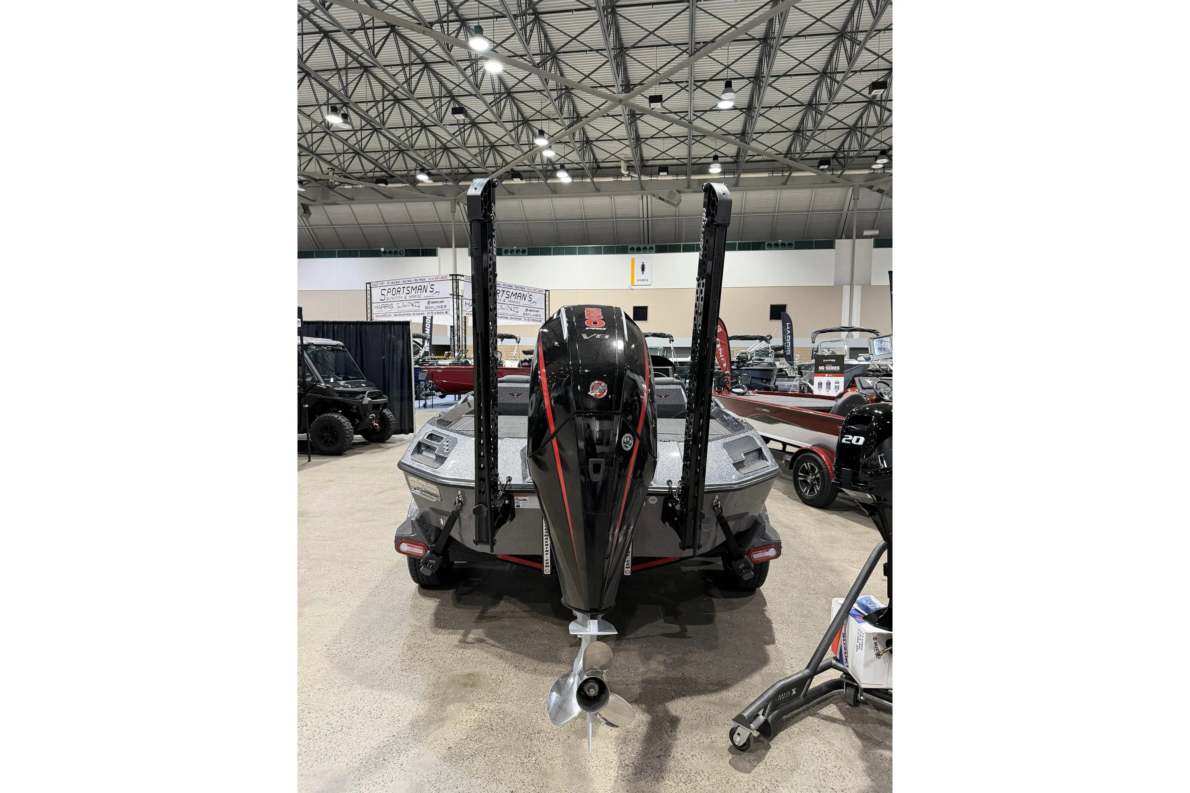 2026 Vexus boat with powerful outboard motor displayed at an indoor exhibition.