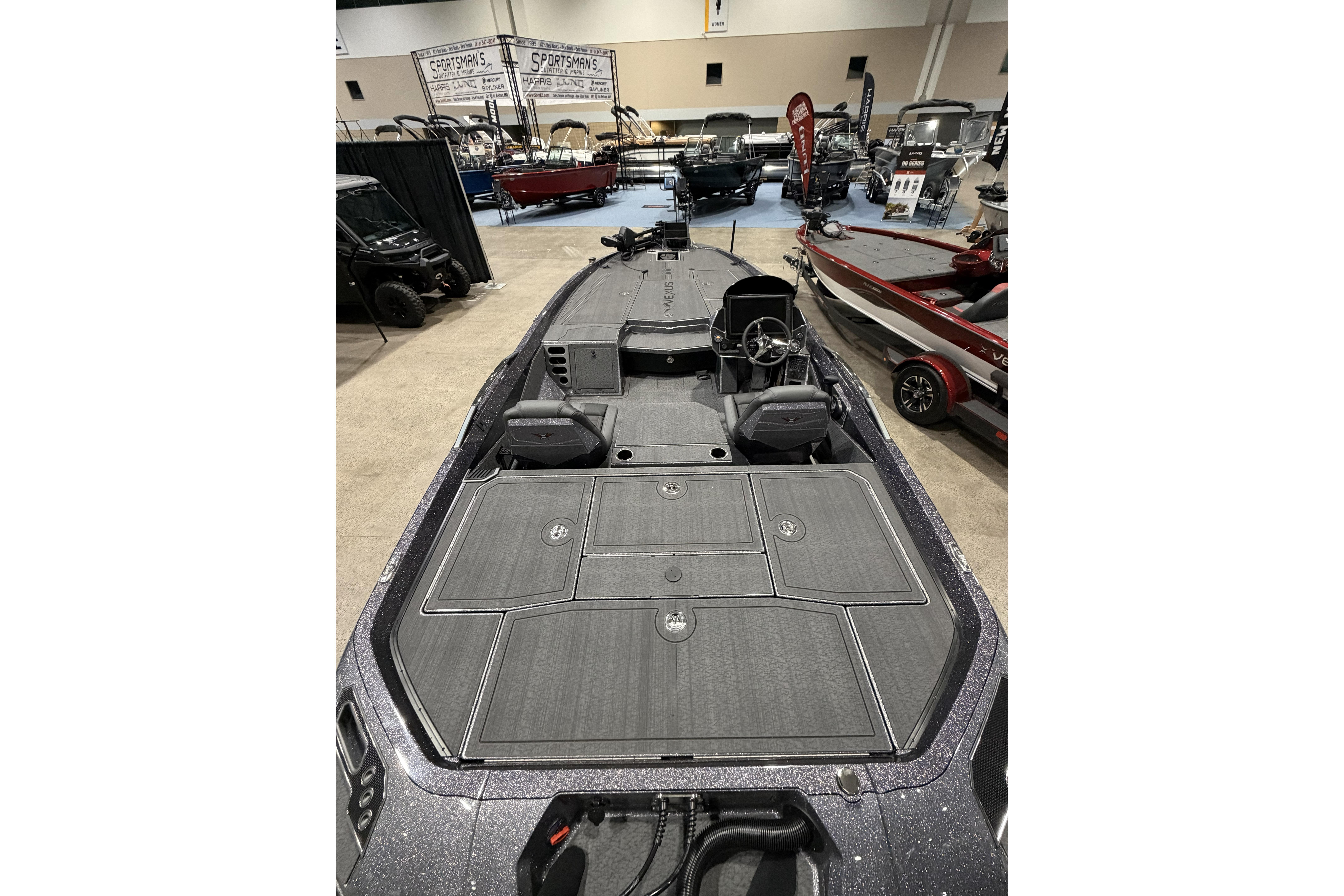 2026 Vexus boat interior at a showroom, featuring spacious deck and modern controls.