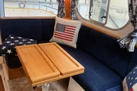 Cozy interior of 2001 Nimbus 345 Coupe with American-themed decor and wooden table.