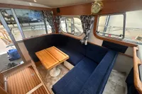 Interior of 2001 Nimbus 345 Coupe with blue seating and wooden table.